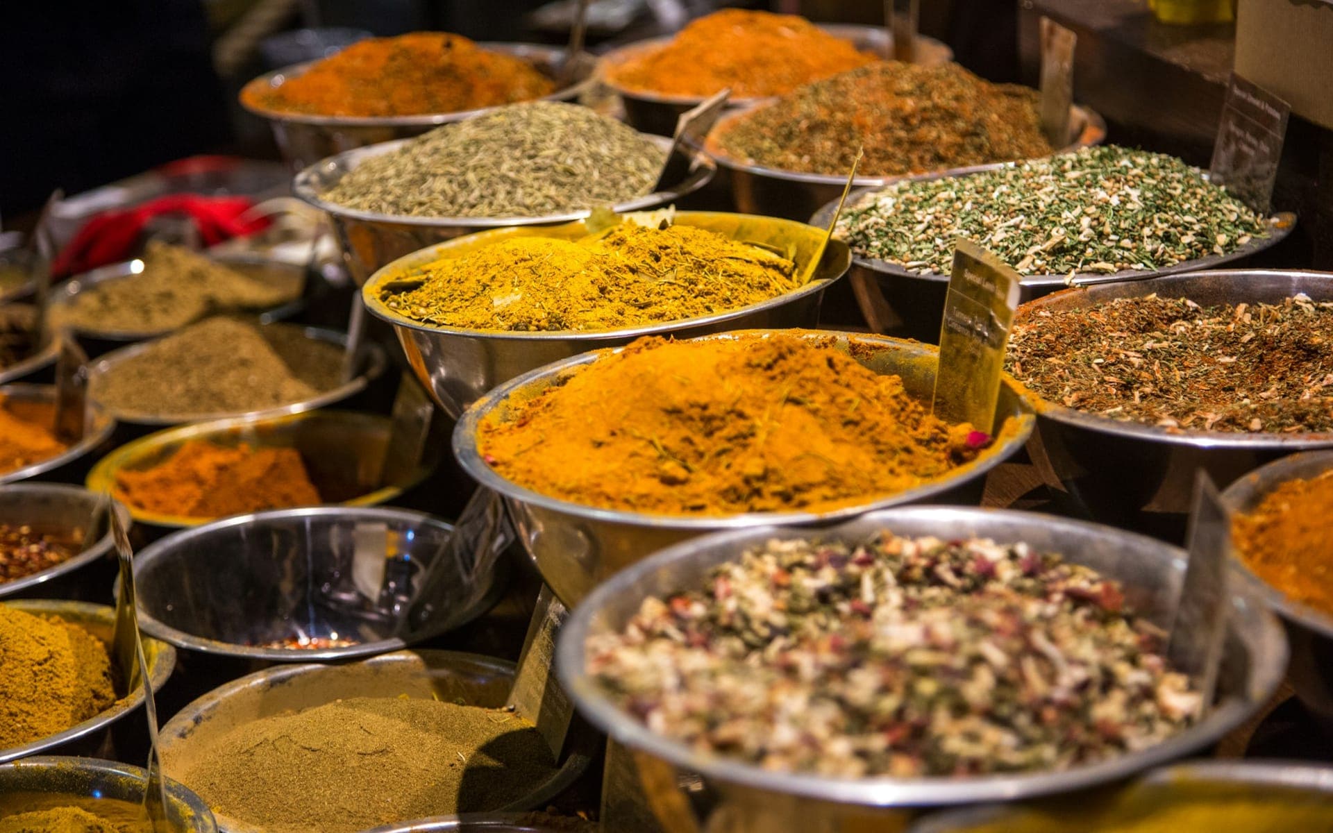 Market bowls heaped with turmeric, dried herbs, and blended spices