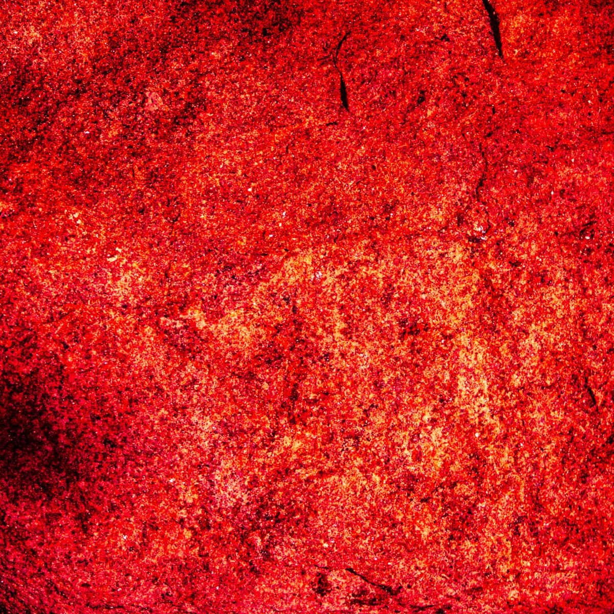 A dense field of coarse red chile flakes